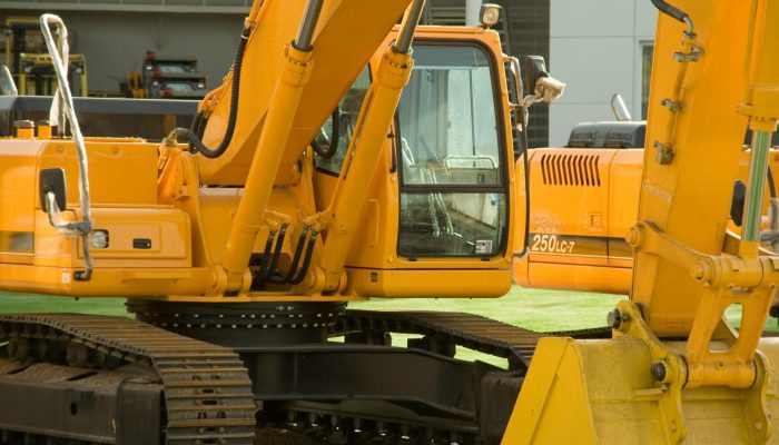 Close-up of yellow excavators at a construction site, showcasing industrial machinery and engineering.